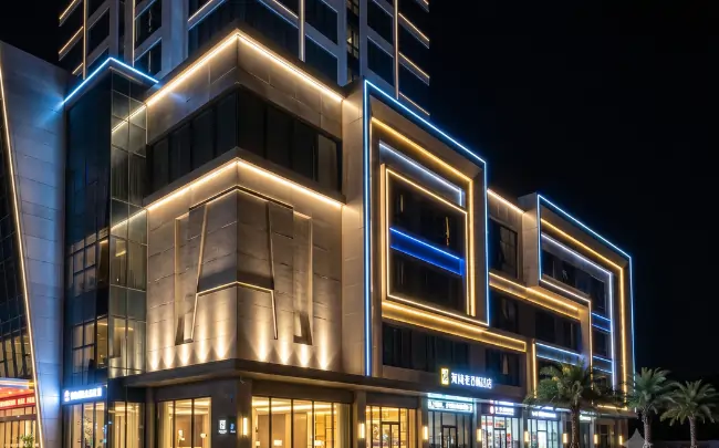 Modern commercial building with stunning LED facade lighting design featuring blue and warm white linear lights on a luxury exterior at night.