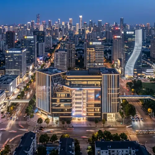 City skyline featuring a modern commercial building with premium facade lighting and LED exterior illumination at dusk.
